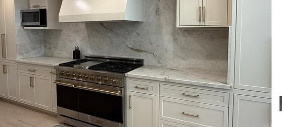 Custom kitchen remodel with white cabinets and marble counters